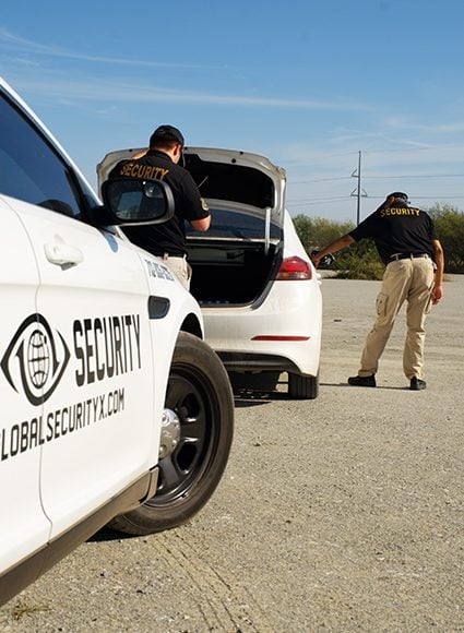 Private investigators from Global Security conducting a thorough investigation near a vehicle, showcasing professionalism and expertise in private investigation services.