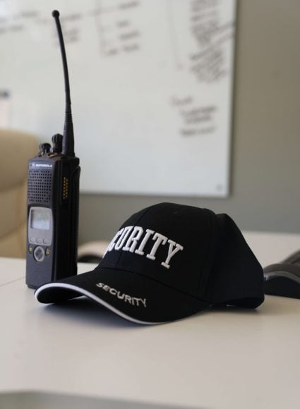 Security cap and radio equipment on a desk, symbolizing professional security guard services for industrial environments in Lake Charles, Louisiana.
